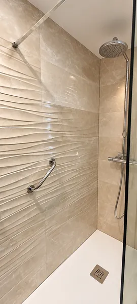 Ducha de obra con revestimiento en relieve y plato de resina