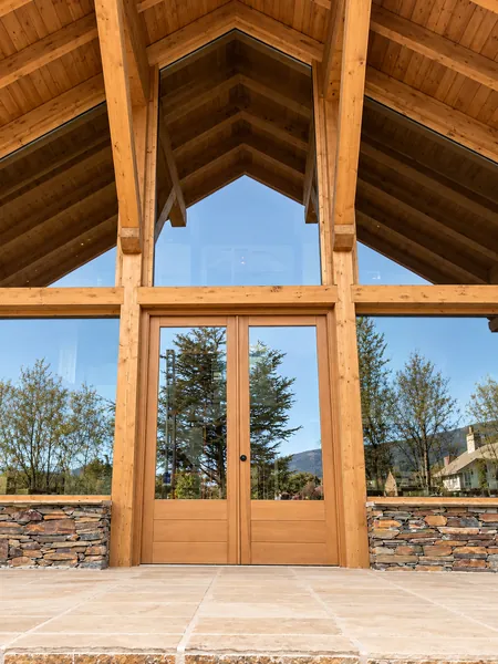 Buhardilla con estructura de madera vista y puerta acristalada al jardín