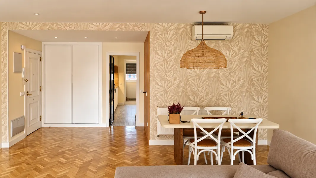 Comedor con parquet en espiga, papel pintado y aire acondicionado